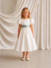 Poppy ivory matte satin flower girl dress by TH&TH with a removable sage green satin sash tied in a bow, front view